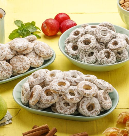 Pratos com biscoitos de pão de mel e biscoito duetto, dispostos ao lado de xícaras de chá.