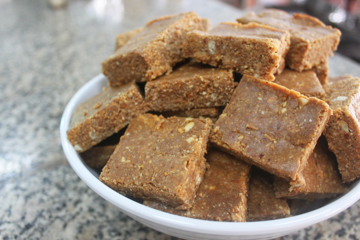 Paçoca com biscoito maisena, servidos em prato sobre fundo desfocado.