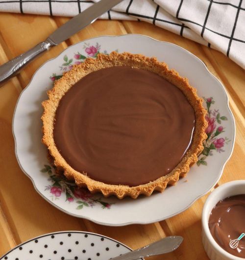 Torta de biscoito Maria e recheio de brigadeiro, servida em prato branco sobre mesa de madeira.