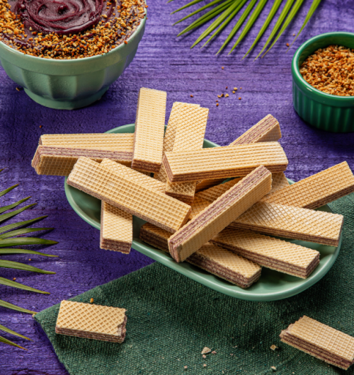Wafer sabor açaí dispostos em prato, sobre fundo roxo.